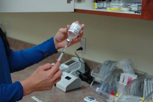 person with medicine bottle and syringe preparing a vaccine injection