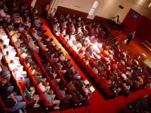 Large group of people in an auditorium for a town meeting
