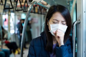 woman wearing mask coughs